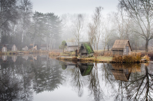 landscape-photo-graphy:Abandoned Fishing Village Outside of Budapest is Perfectly Reflected on the Lake by Viktor Egyed A few miles outside of Budapest lays a small abandoned fishing village composed of rustic huts, tall trees and an obscure atmosphere.