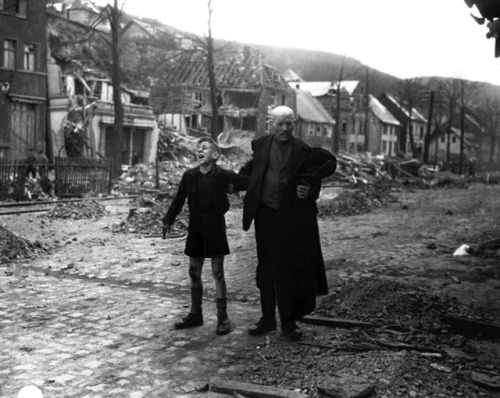 historicaltimes:An elderly German man rushes a young boy, screaming in pain, to an Allied aid statio