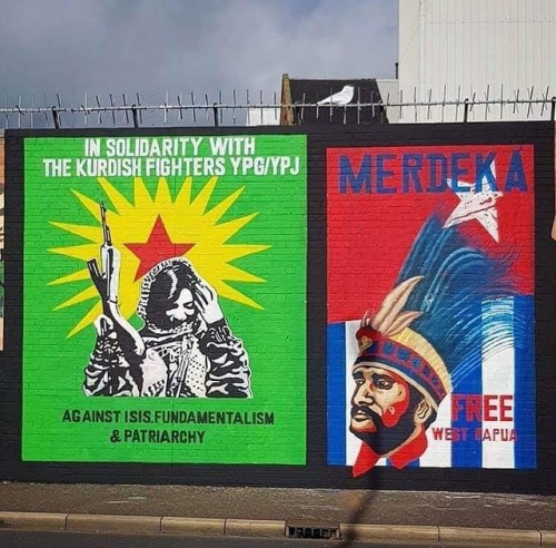 Rojava & West Papua solidarity murals seen along the Falls road in Belfast, Northern Ireland
