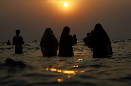 o-g-steve:awkwardsituationist:indian hindu devotees offer prayers to the sun in the arabian sea duri