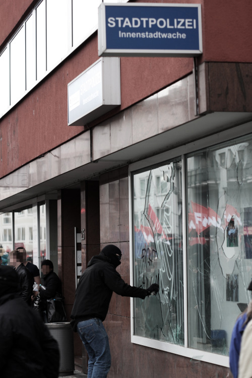 nebenwiderspruch:  Anticapitalist sprays “Fight Law and Order” on a police station during a demonstration in Frankfurt 