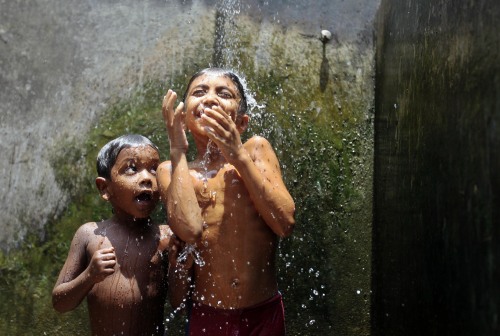 Children cool off at Mohammadpur Geneva refugee camp in Dhaka, Bangladesh on July 30, 2013.[Credit :