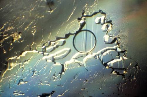 Fluid inclusion.This jagged edged hollow in a blue topaz magnified 18x is filled with liquid and a b