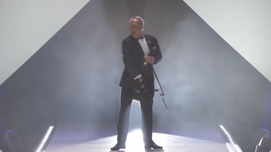 prince-of-eros:  snickerdoodle-writes:  So is no one gonna talk about how Darin de Paul (voice of Reinhardt) came out on stage at Blizzcon in a tuxedo and wearing a Reinhardt pin while tossing candy to the audience and almost cried while speaking because