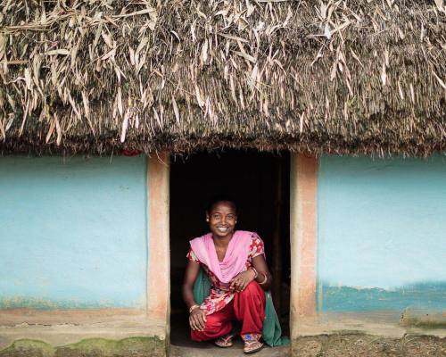 Cheerful Manjali Hasda in the doorway of her village...