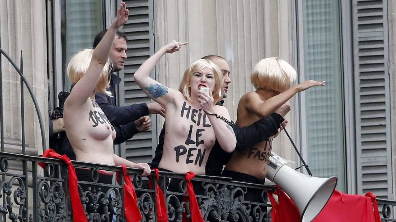 FEMEN. Los guardias de seguridad detienen a activistas de Femen en topless que realizan el saludo nazi desde el balcón contra el partido político Frente Nacional de Marine Le Penn de extrema derecha de Francia durante un mitin FN en honor a Juana de...