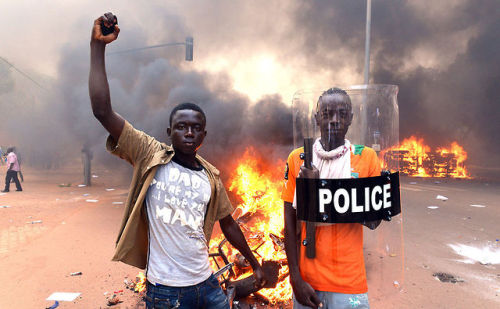 politics-war:  Protesters pose with a police shield outside the parliament in Ouagadougou on October