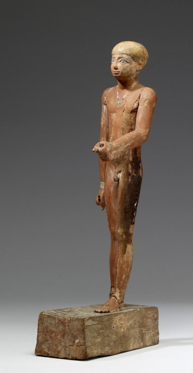 Ancient Egyptian statue (carved wood with polychromy) of one Imti, shown as a nude youth wearing an 