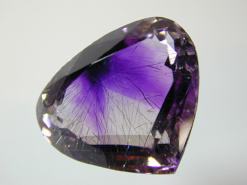 unearthedgemstones:  mineralists:  Hematite “ribbons” trapped inside a faceted