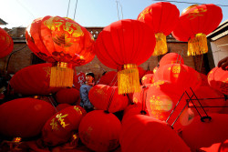 fotojournalismus:  A villager arranges red lanterns at Xubeizhang Village, in central China’s Henan Province on January 20, 2013, in preparation for the coming Lunar New Year. [Credit : Zuma Press] 