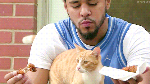 kingpinnn:  j cole eating chicken holding a cat.