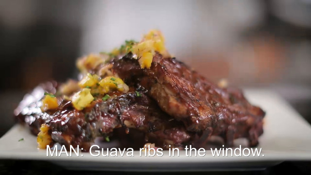 98% sure it's a close up of a plate of food. Caption: MAN: Guava ribs in the window.