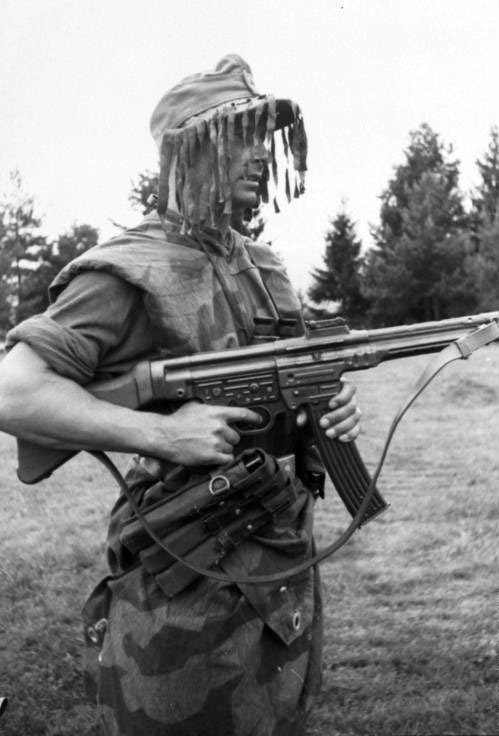 A German infantryman with a StG.44 wearing ‘splinter’ camouflage and a ghillie cap.