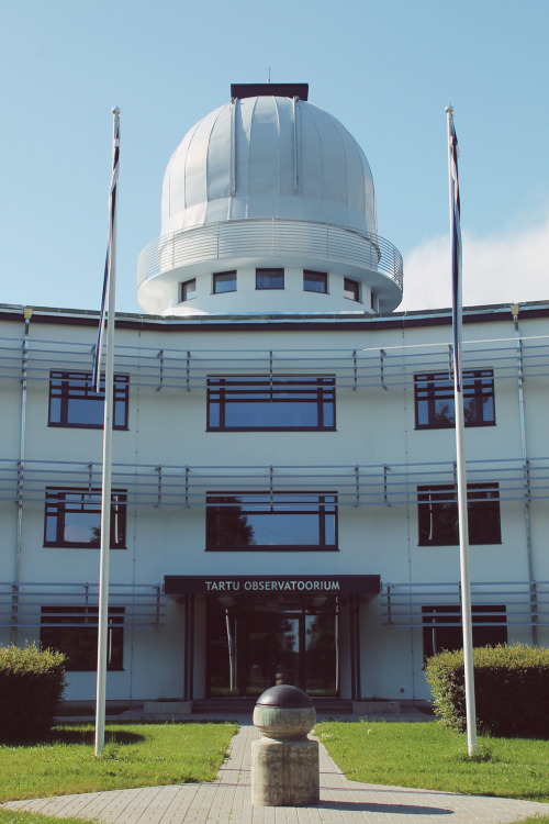 sci-universe:  The badass place in where I spend 5 days a week. (read and see more here) In front of the main building stands a sundial, a clock that tells the time of day by the position of the Sun:  and you can also see Estonian flags (blue-black-white)