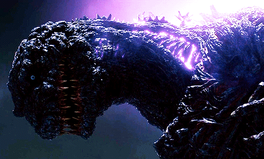 A GIF of Shin Godzilla opening his mouth to reveal a glowing purple light.