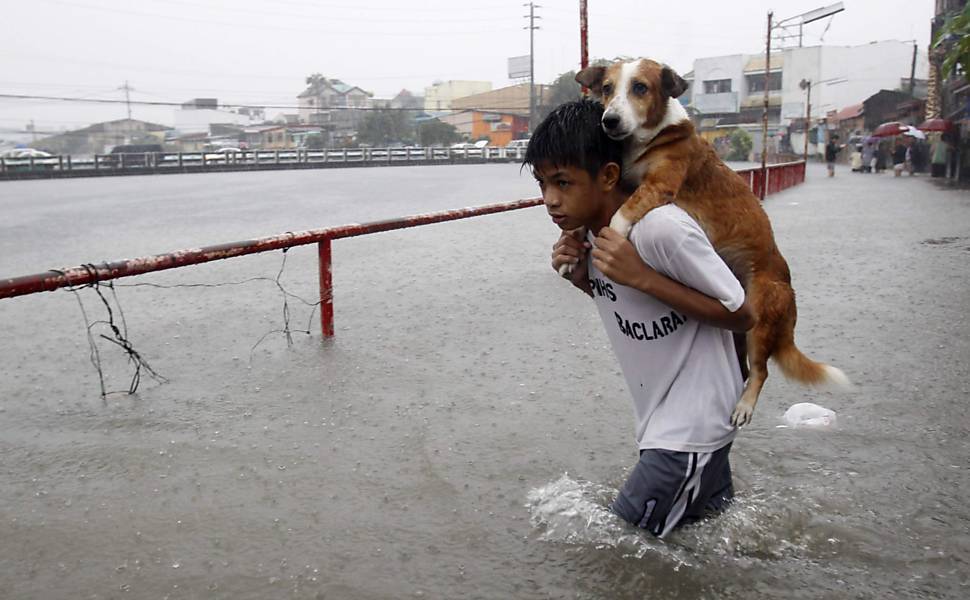 Garoto carrega cão durante alagamento causado por chuva de monção na região metropolitana de Manila (Filipinas); veja mais imagens do dia: http://uol.com/bldcwS
Foto: Romeo Ranoco/Reuters