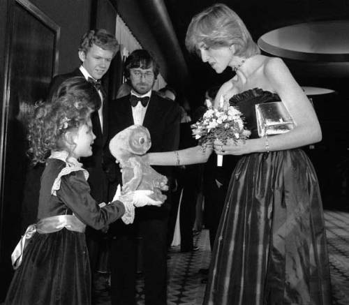 Drew Barrymore giving Princess Diana an E.T.-doll while Robert MacNaughton and Steven Spielberg is l