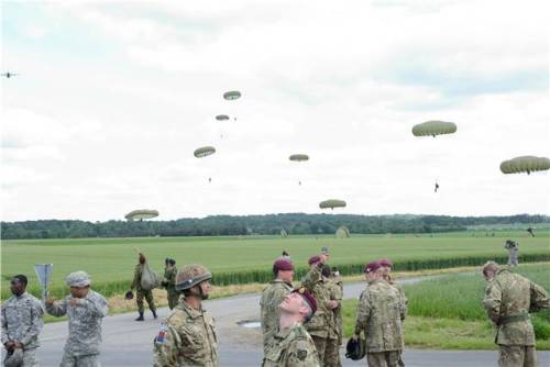 Paratroopers from around the world watch as the rest of their man land in the fields outside Ranvill