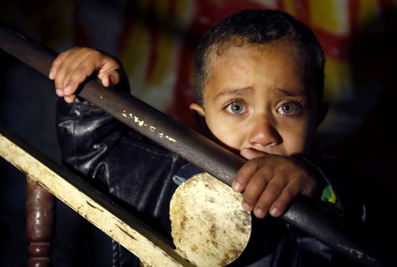 palestiniangirl88:   A Palestinian boy watches the funeral of three children in