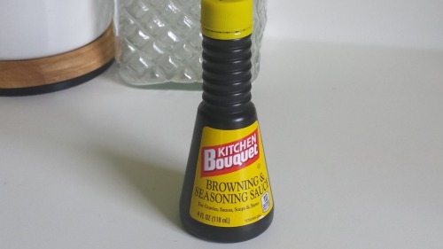 A dark brown plastic bottle with a yellow and red label.