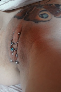 Barbells and rings through her labia, chastity piercing. Christina piercing and butterfly tattoo.