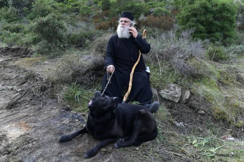 elladastinkardiamou: A Greek Orthodox priest speaks on his cellphone as he holds a dog at a roadbloc