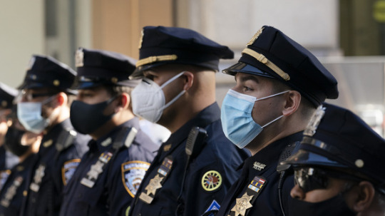 New York Police Department officers in masks stand during a service at St. Patrick