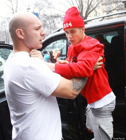 juilan:  Justin Bieber being placed in his car seat by bodyguard   Who dresses this kid????