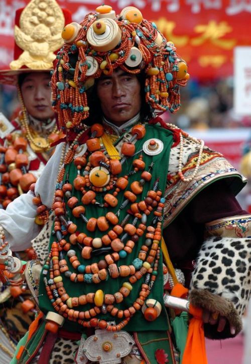 Khampa people, Tibet (Click to enlarge) The large orange-red beads are coral. These huge coral neckl