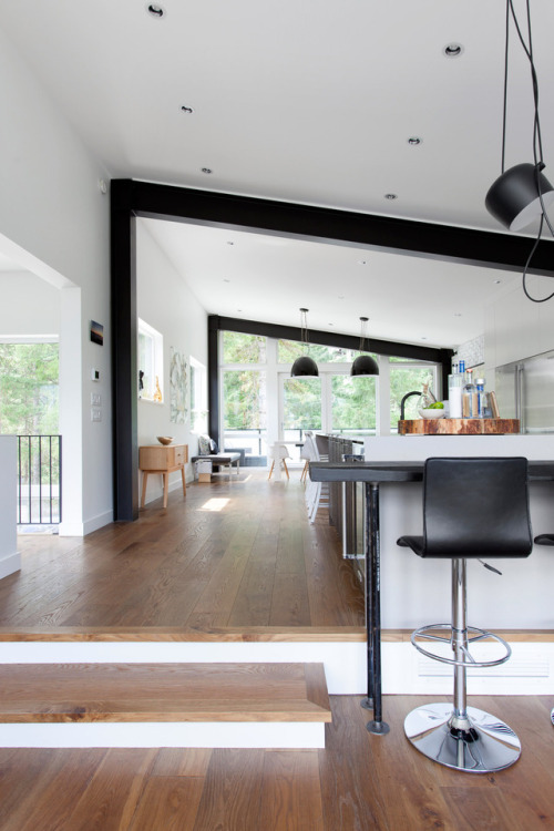 interior-design-home: Open plan kitchen and dining area has a slanted ceiling supported by industria
