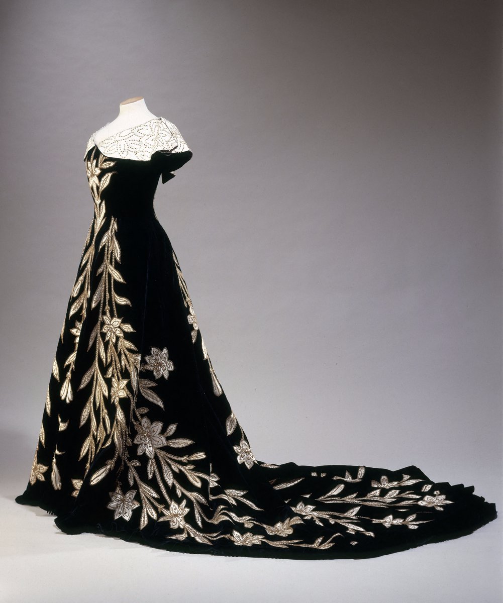 history-of-fashion:
“ ab. 1896 The ‘Lily’ evening gown by House of Worth
Black silk velvet, white silk satin (for the partially modern collar), white satin appliqués embroidered with metal cannetilles and gold sequins.
(Palais Galliera, musée de la...