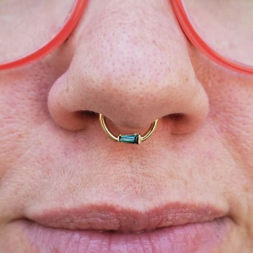 Making a statement with this fresh septum piercing, rocking a tapered baguette london blue topaz rin