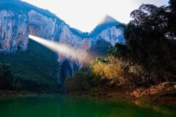 madness-is-my-life:  fullmetal-atheist:  sixpenceee:  A ray of light shines through the Great Arch of Getu in China. (Source)  behold the mountain dragon and its breath of light  I’d be looking for the secret entrance to the treasure chamber… 