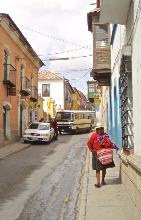 Escena de la calle con la mujer, un automóvil y un autobús, Potosí, Bolivia, 2006.