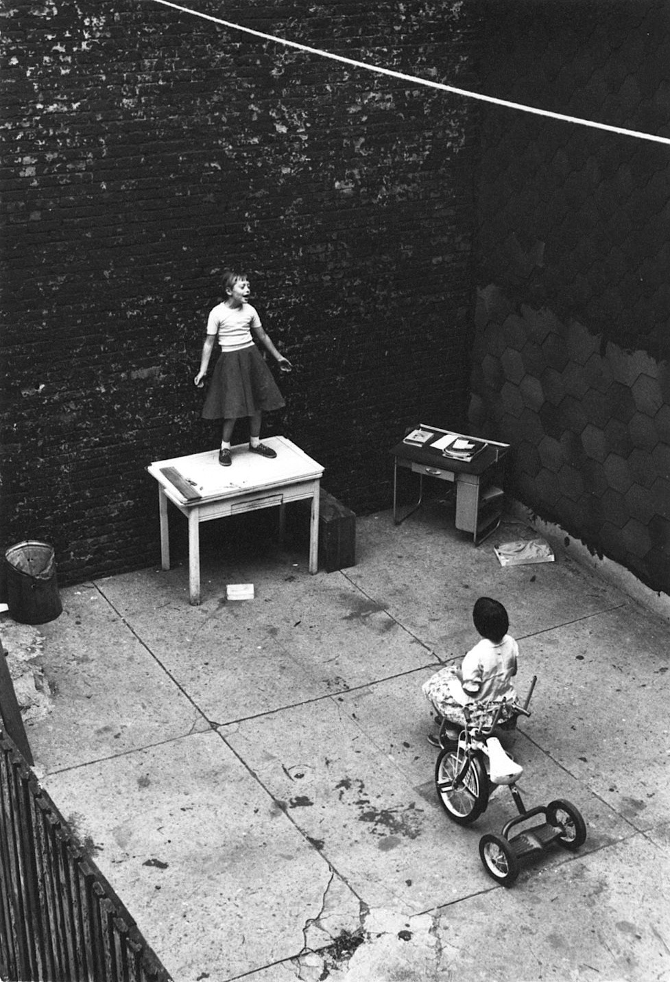 luzfosca:  William Gedney Girl standing on desk in courtyard, performing for a seated