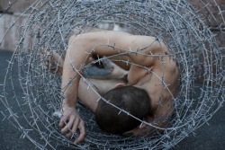 weepling:  In May, protest artist Pavlensky attracted attention by wrapping barbed wire around his naked body outside St Petersburg’s parliament, a symbol for human existence inside a “repressive legal system”. 