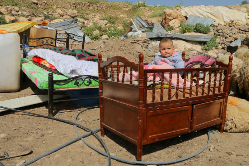 ta7yafilisteen:Palestine, West Bank.A Palestinian baby sits in a crib after the child’s family home 