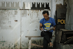 Man reads newspaper. A police riot shield