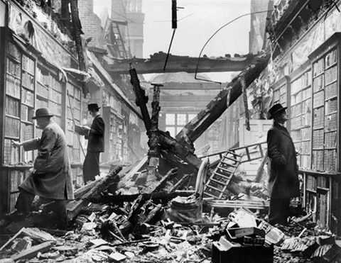 Unos lectores continúan buscando libros entre las estanterías de una biblioteca londinense bombard