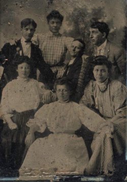 historical-nonfiction:  An early tintype of a group of friends. One man, thinner than the others, is seated in a wicker wheelchair in the center of the group, head turned toward the camera. He was likely disabled, one of the earliest photographs of a