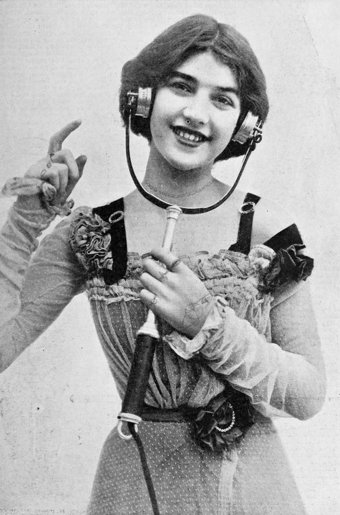 chubachus:   A young woman wearing an electrophone with which she could listen to live entertainment such as plays and concerts over the telephone line, 1901. By Foulsham and Banfield. More information. 