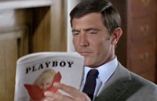 dollsofthe1960s:  James Bond (played by George Lazenby) seen above enjoying his February 1969 Playboy issue in “On Her Majesty’s Secret Service (1969).”  GRINDHOUSE® 007