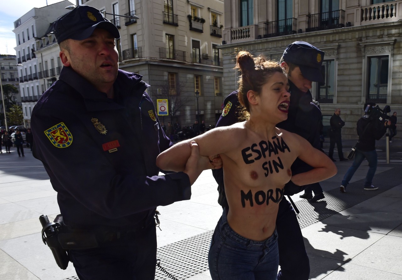 ESPAÑA. Dos activistas de Femen protestan frente al Congreso contra la ‘ley mordaza’al grito de “Protestar no es ilegal” y con los lemas “Femen for freedom” y “España sin mordaza” escritos en el torso y en la espalda desnudos. (AFP)