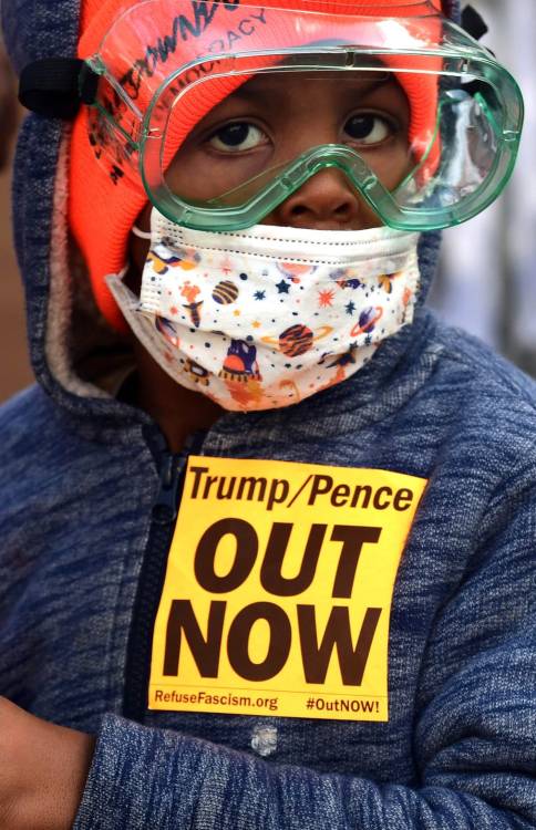 Washington DC, USAA young boy joins community members as they replace protest art on the fence surro