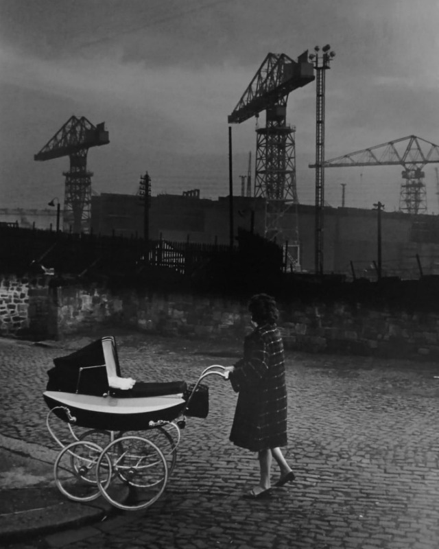 Mother with pram walking past Swan Hunters shipyard, Wallsend, England, 1962 - by Colin Jones (1936&hellip;