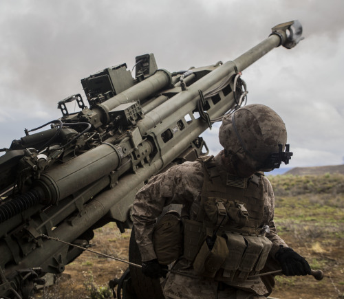 Hell’s Bells.Cpl. Calvin V. Montgomery uses his whole body to pull the lanyard of an M777 Howitzer, 