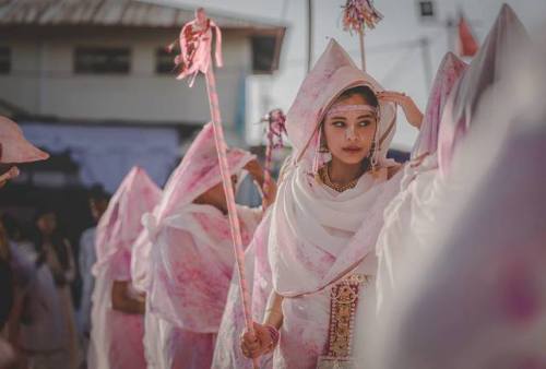 Beautiful veiled woman protecting themselves from the colored powders, Holi Festival at Radha Govind