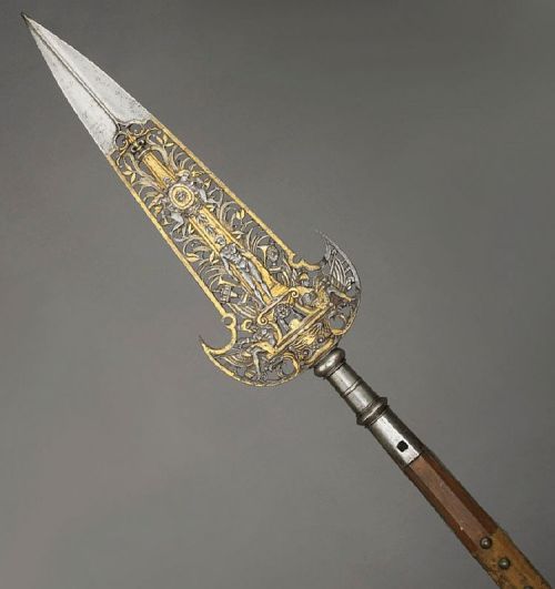 art-of-swords:  Partizans Photo #1 Attributed to Jean Berain I (1640 - 1711) Dated: circa 1670 - 1680 Culture: French Medium: steel, gold and velvet, etched, chiselled and gilded Measurements: blade length: 53.2 cm, straps length: 7.3 cm. Weight: 1.92 kg