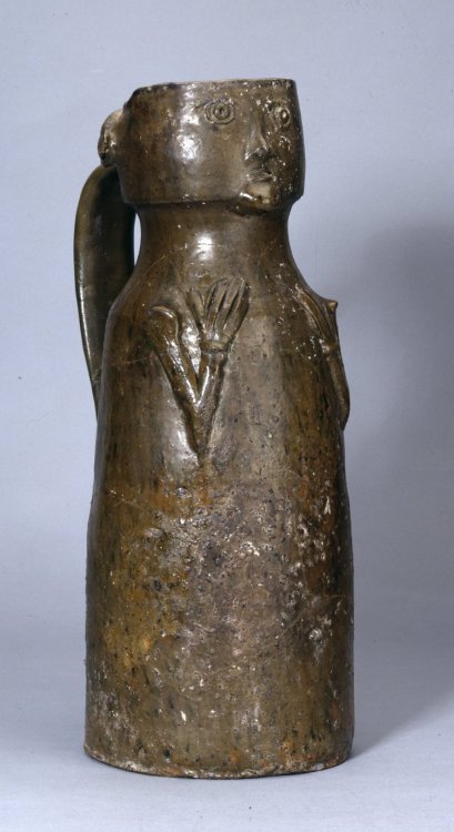 Pottery face jug (early 1300s), found at Worcester Cathedral andrestored from fragments.The arms are