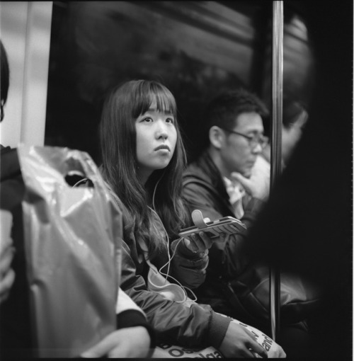 letmephotographyousoftly:title    in the train/winter/a girl looking at some advertisement hanging o